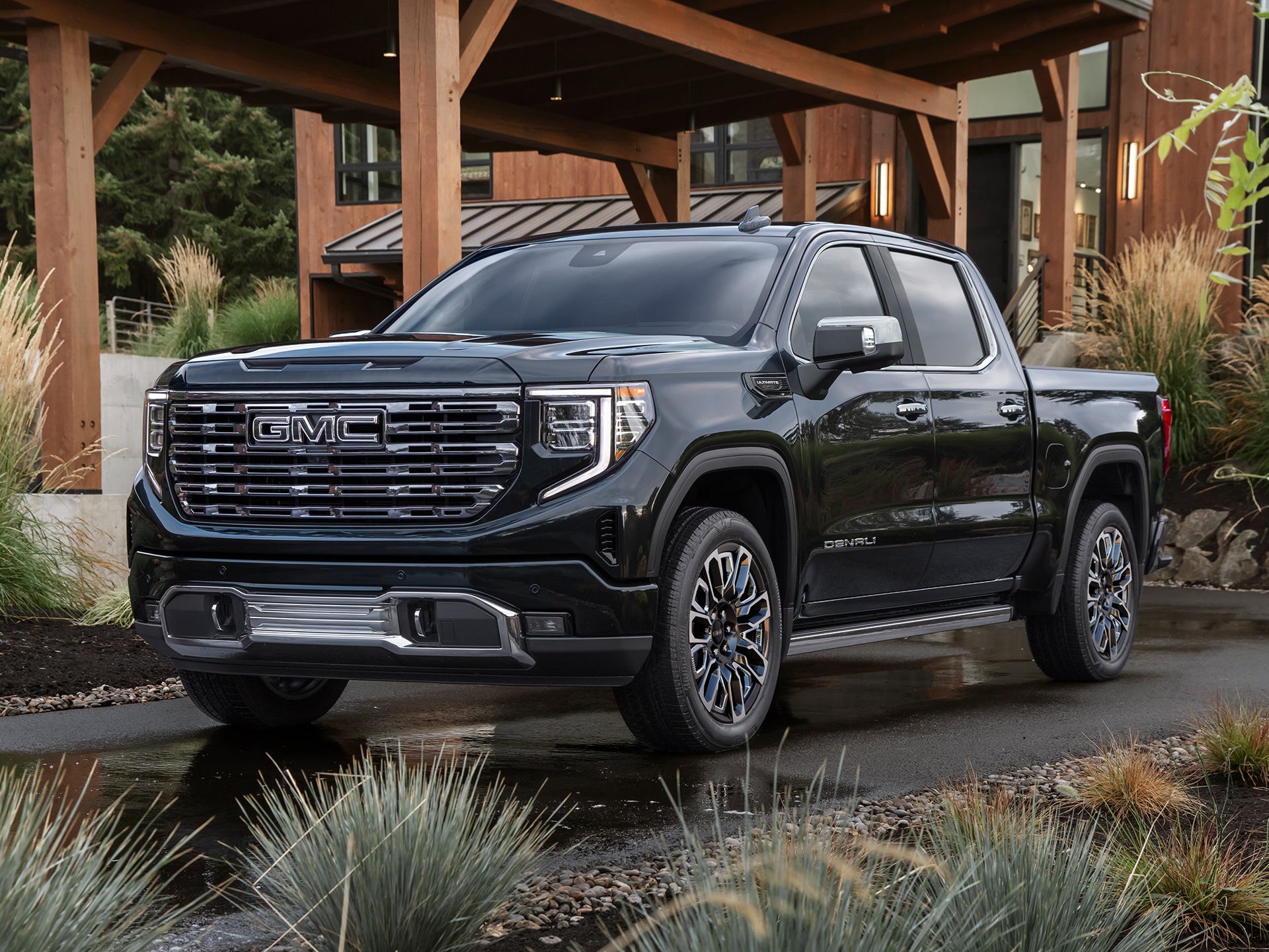GMC Sierra 1500 2026 stationné devant un chalet en forêt